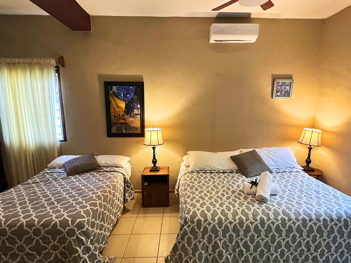 A hotel room with two beds and a ceiling fan