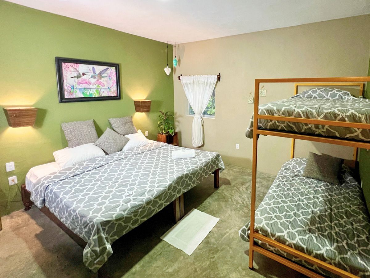 A hotel room with two beds and a bunk bed.