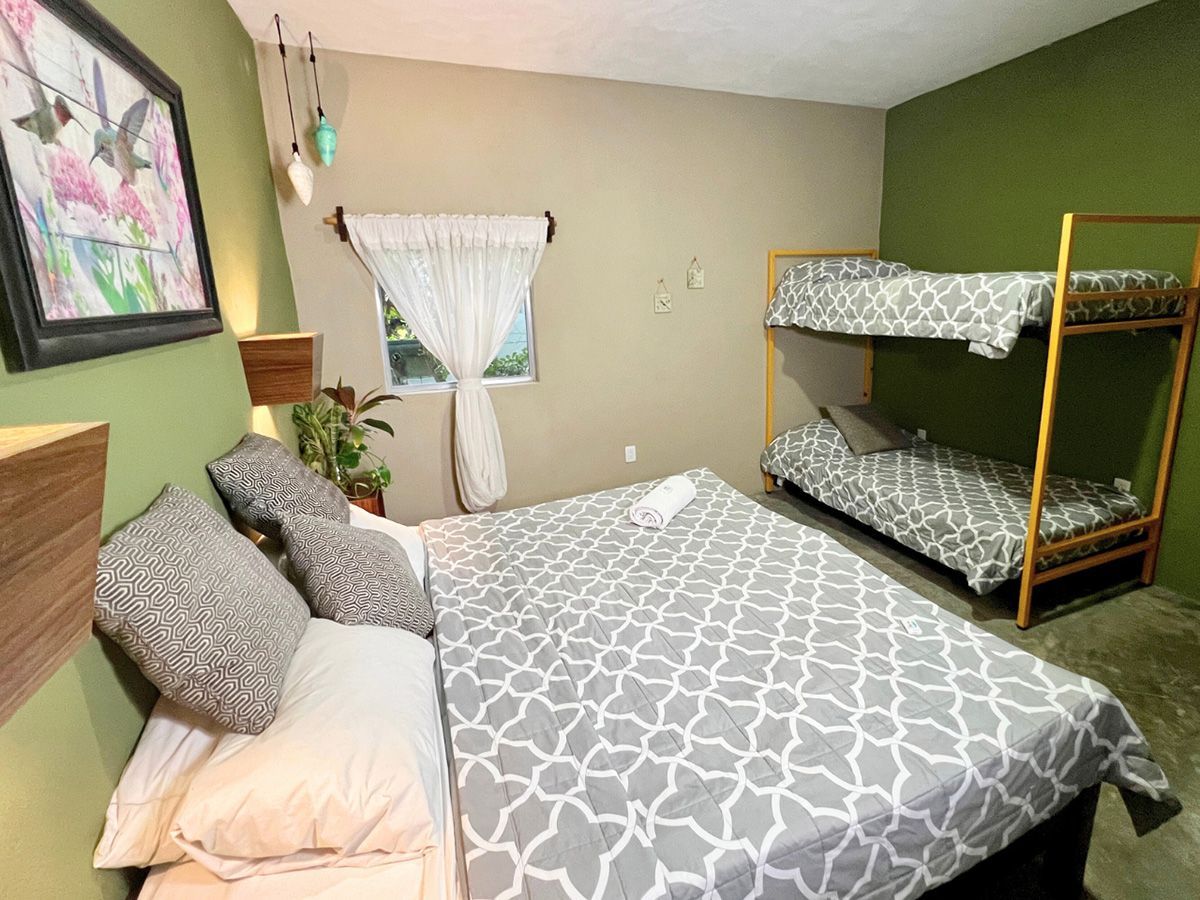 A hotel room with a king size bed and two bunk beds.