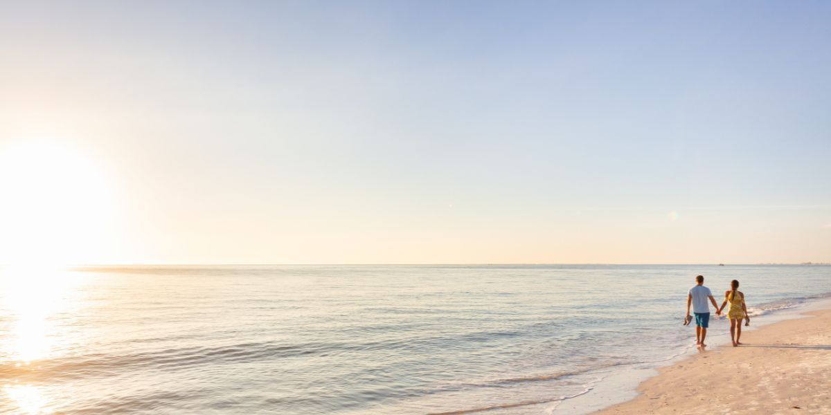 A couple waling in Carolina Beach during sunrise