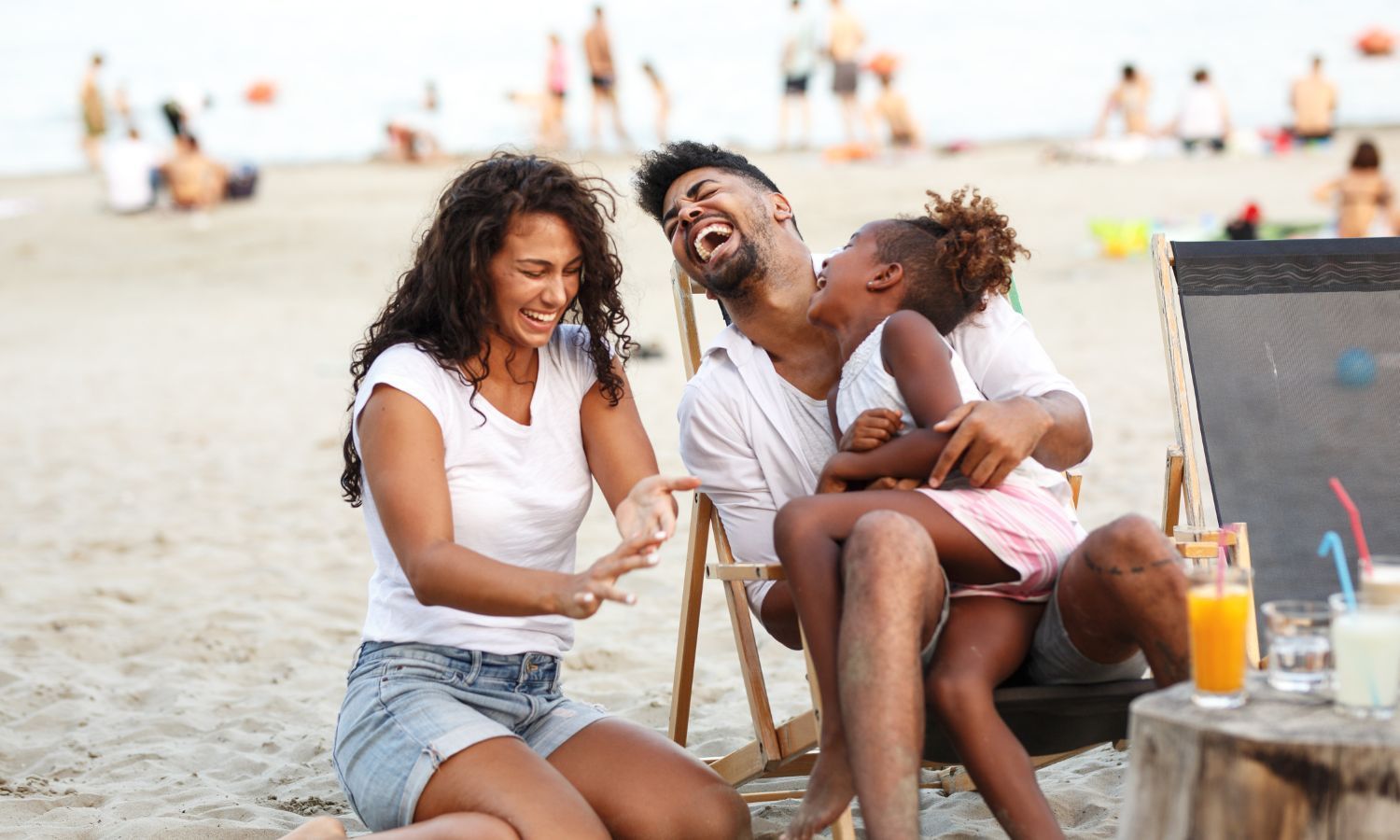 Family enjoying the beach and laughing together on Carolina Beach near the inn.