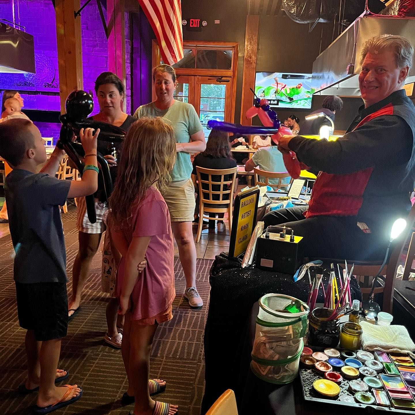 A group of kids waiting for their balloon animals at desaki Restaurant