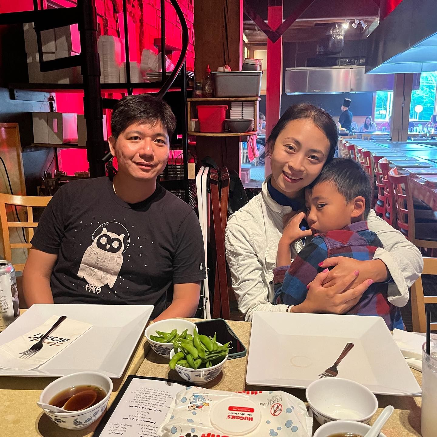 A family of 3 posing for a picture at the hibachi table at desaki
