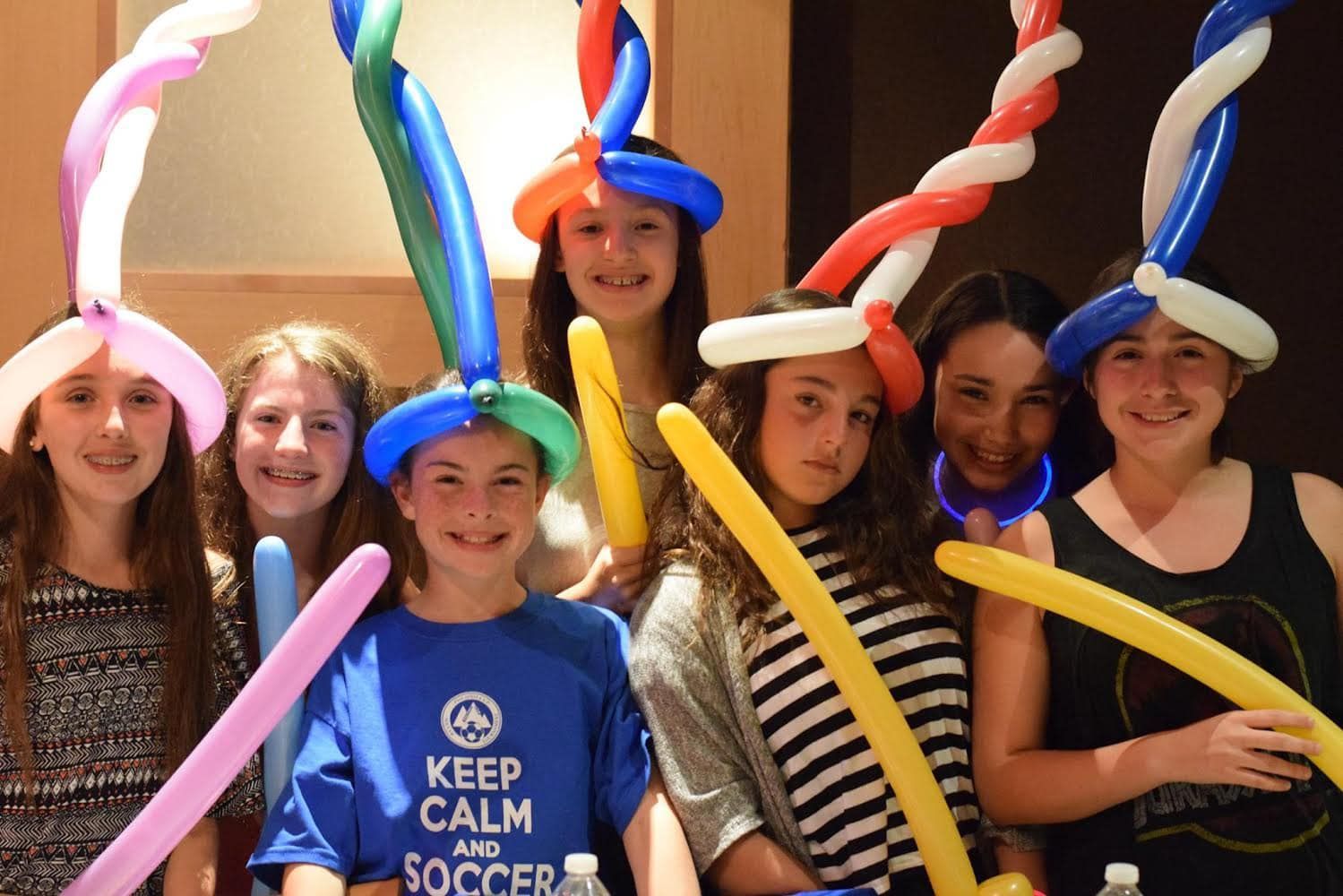 A group of kids posing for a picture with their balloon animals at desaki