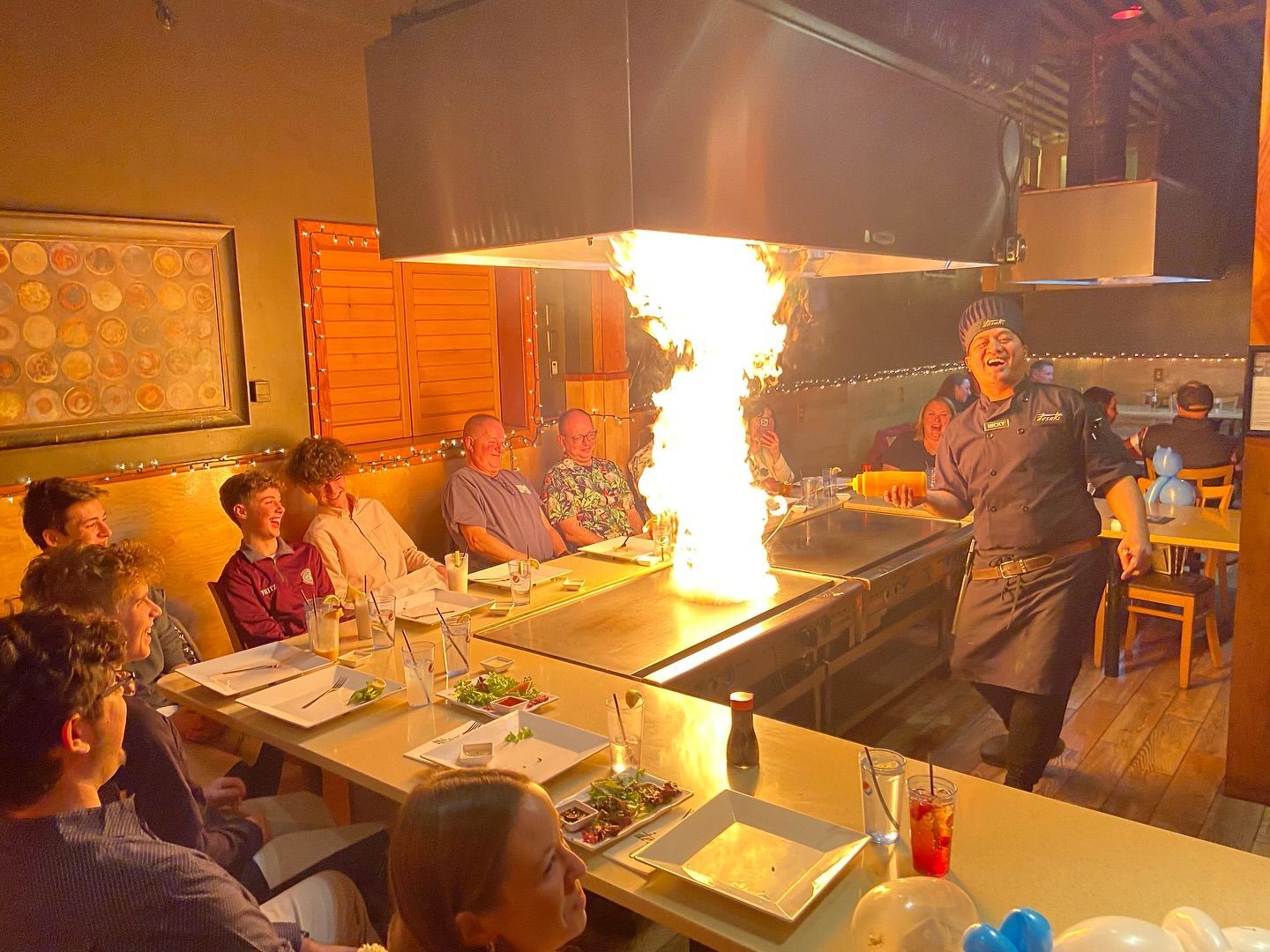 A group of people amazed by the fire show at desaki Restaurant