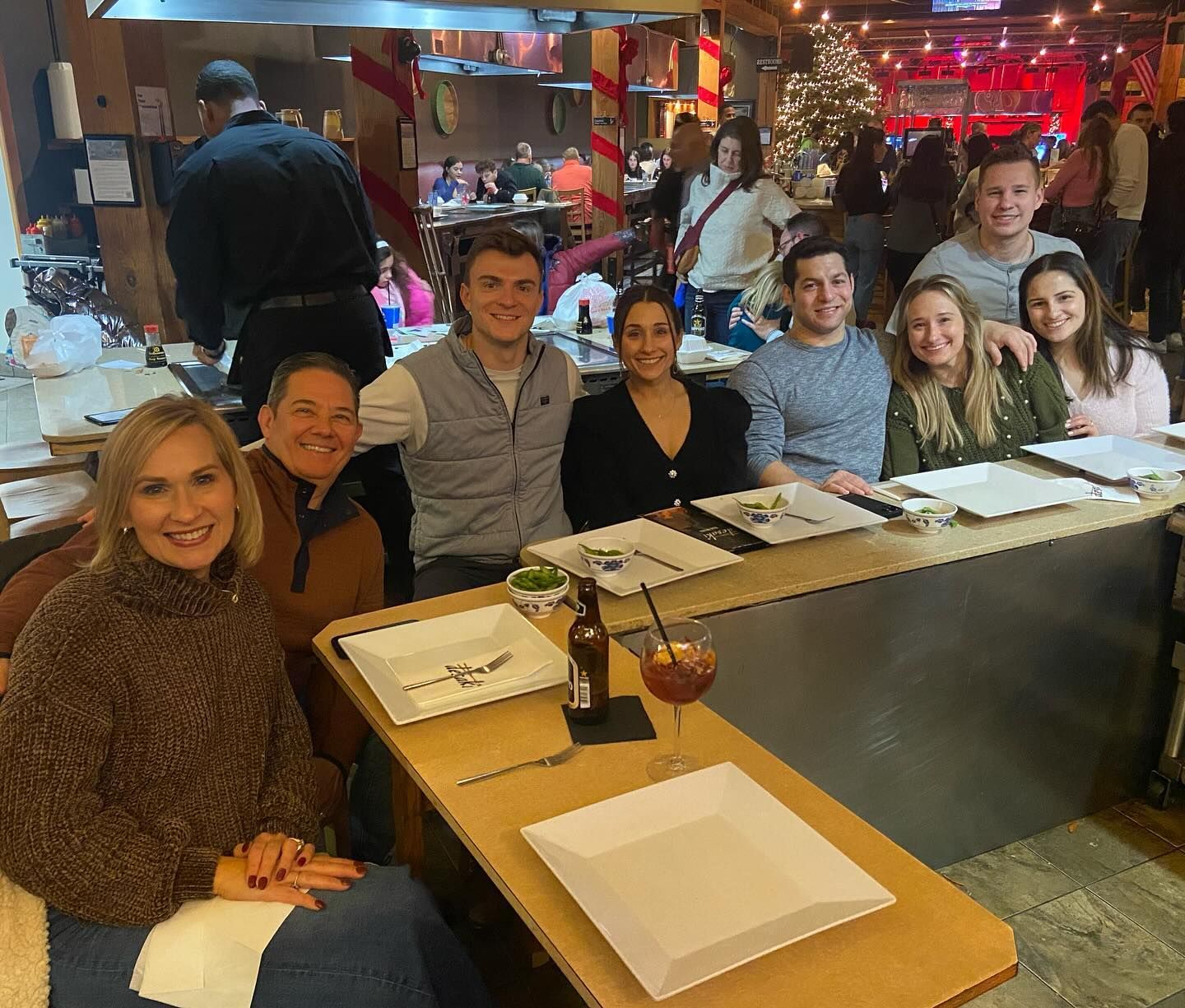 A group of people are posing for a picture at a table in desaki