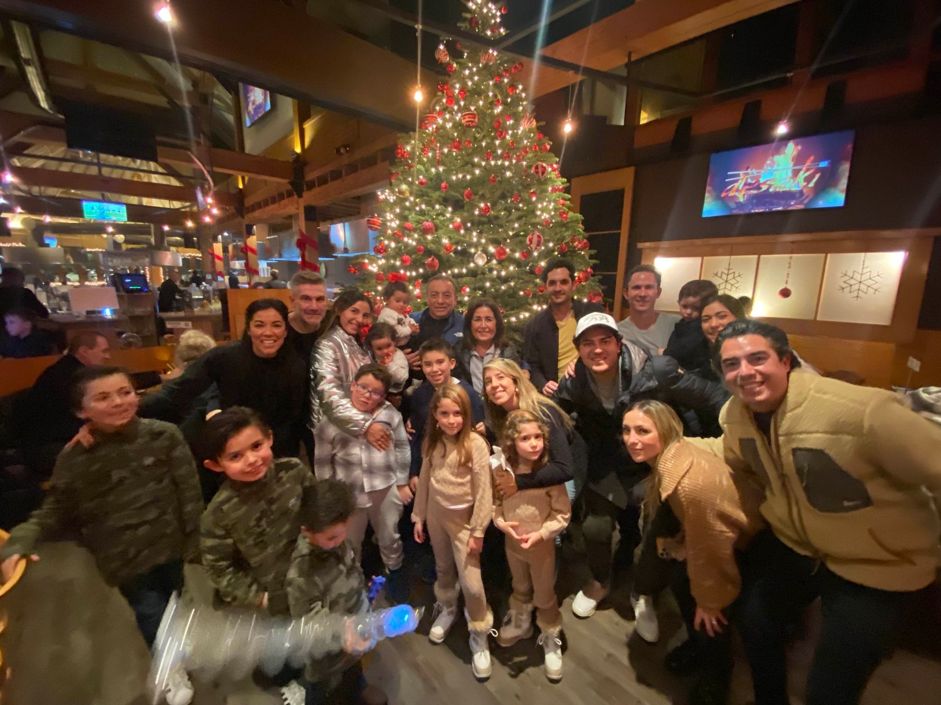 Family posing for a picture in front of the tree at desaki