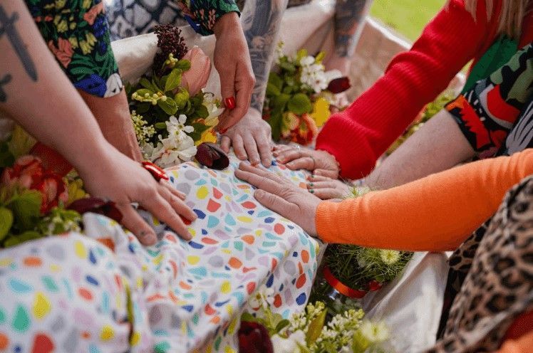 Family members placing hands together in support during direct cremation Albuquerque, NM service