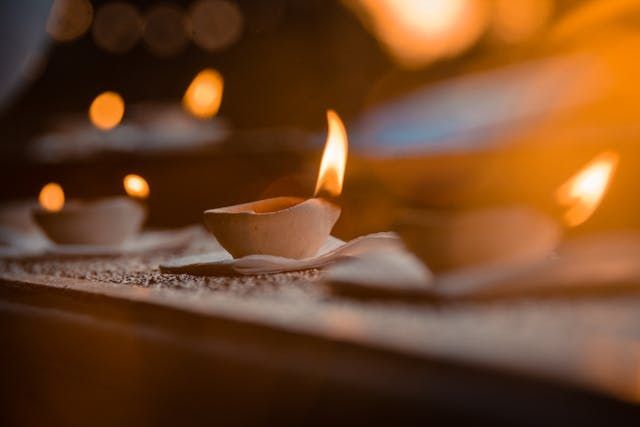 Soft candle flames glow in warm, blurred light with direct cremation in Rio Rancho, NM