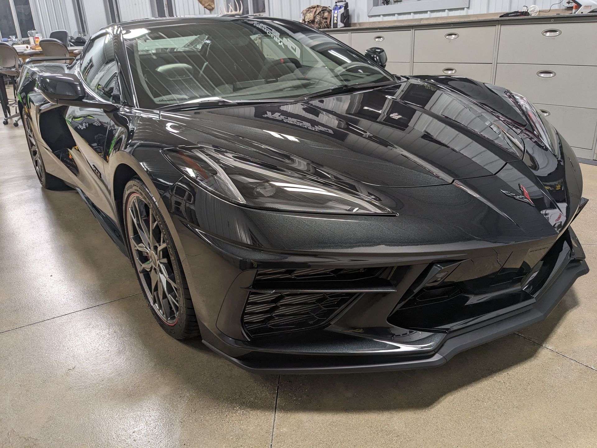 A black sports car is parked in a garage.