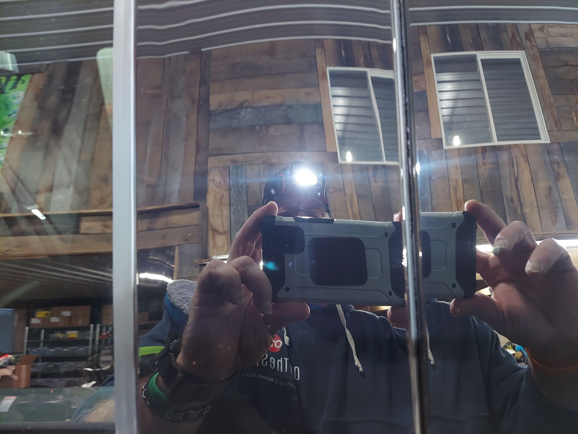 A person is taking a picture of their reflection in a mirror