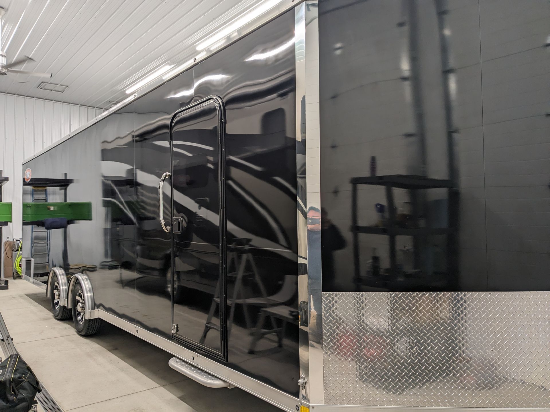 A black trailer is parked in a garage.