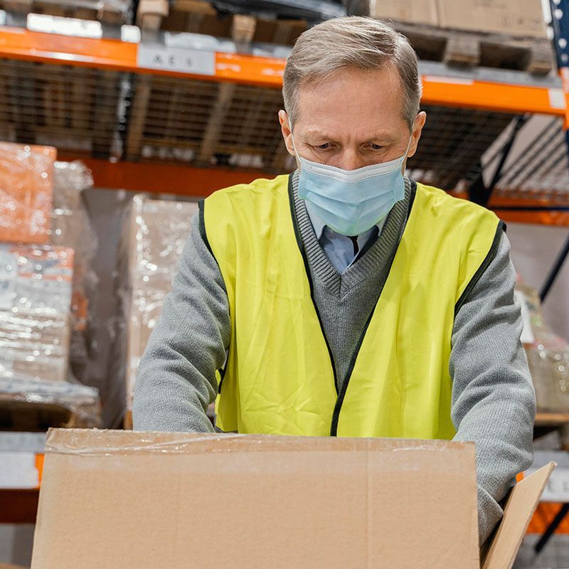 A man wearing a protective face mask handling hazardous goods