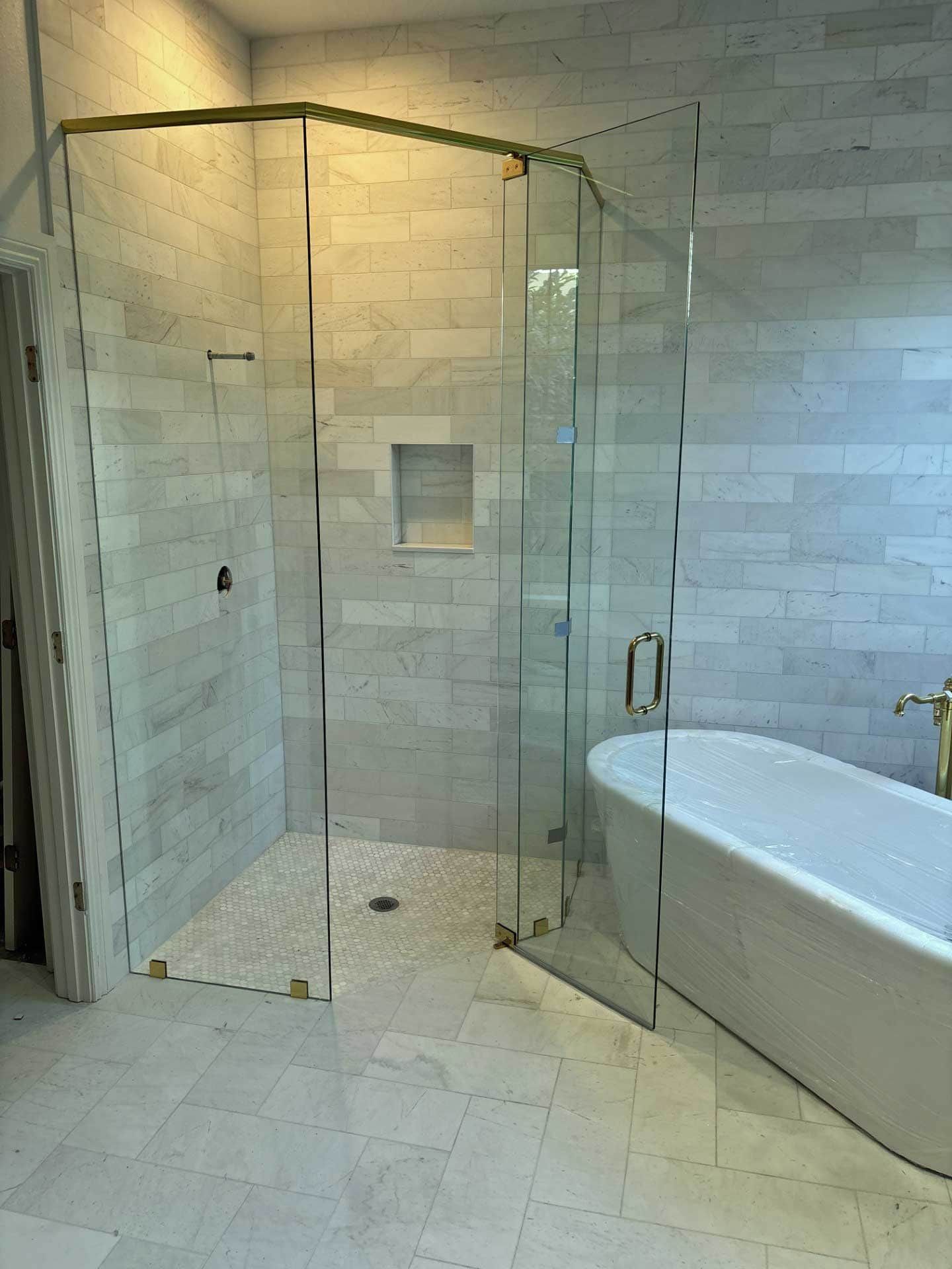 Modern tiled bathroom with glass shower enclosure and freestanding bathtub remodel 