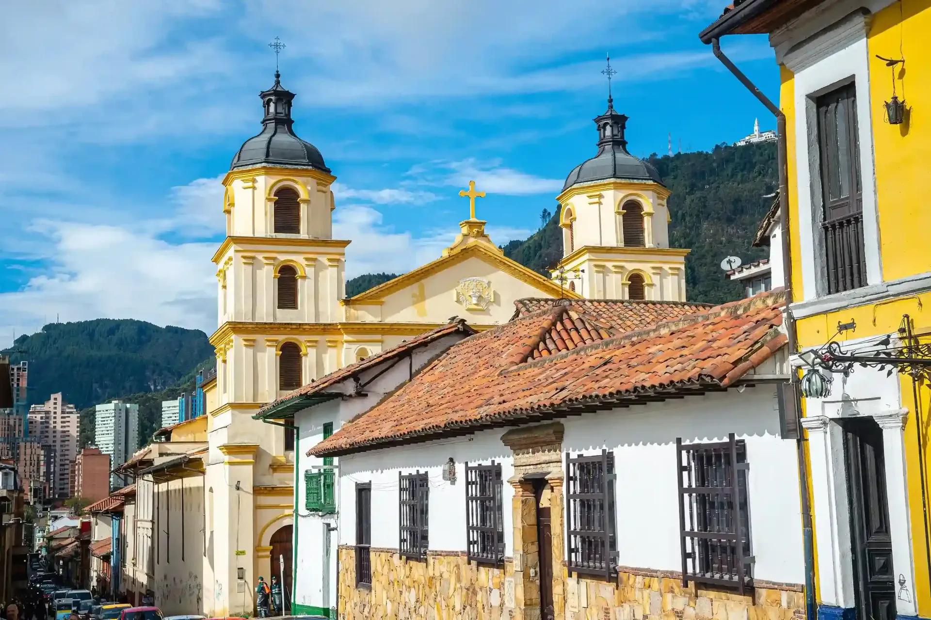 Iglesia colonial en Bogotá, arquitectura histórica con montañas al fondo, uno de los mejores planes en Bogotá para recorrer la ciudad.
