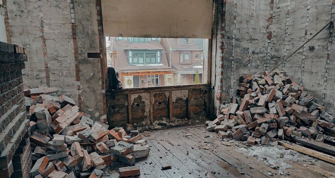 A room with a pile of bricks on the floor during a demolition job.