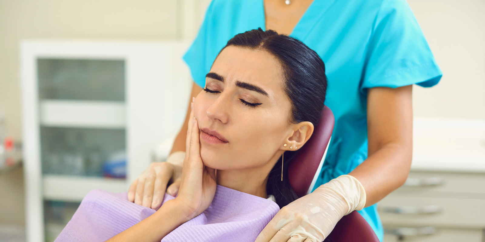 Woman receiving a facial massage from a therapist in a spa setting