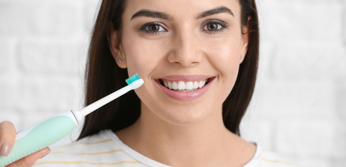 Person practicing good oral hygiene by brushing teeth at home