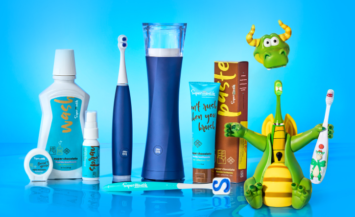 Assorted colorful toothbrushes, toothpaste, and a mouthwash bottle on a bright blue background