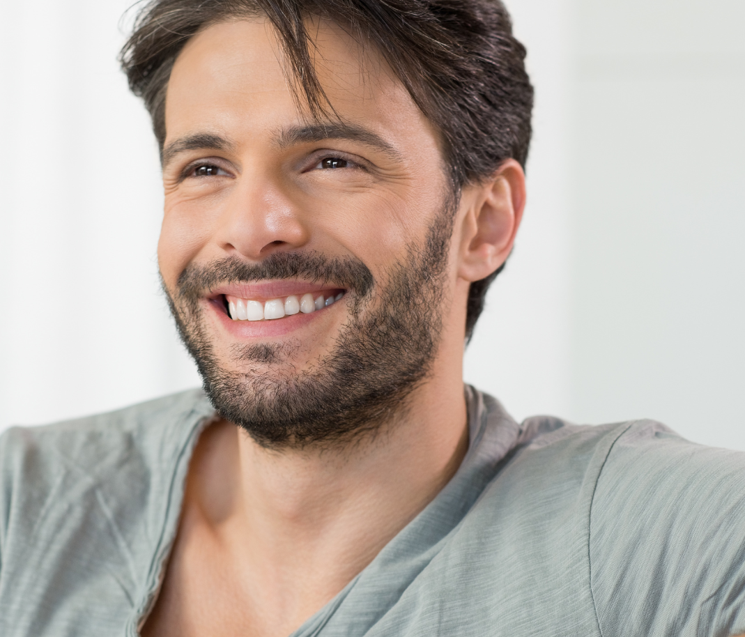 Man with dark hair and a beard smiling