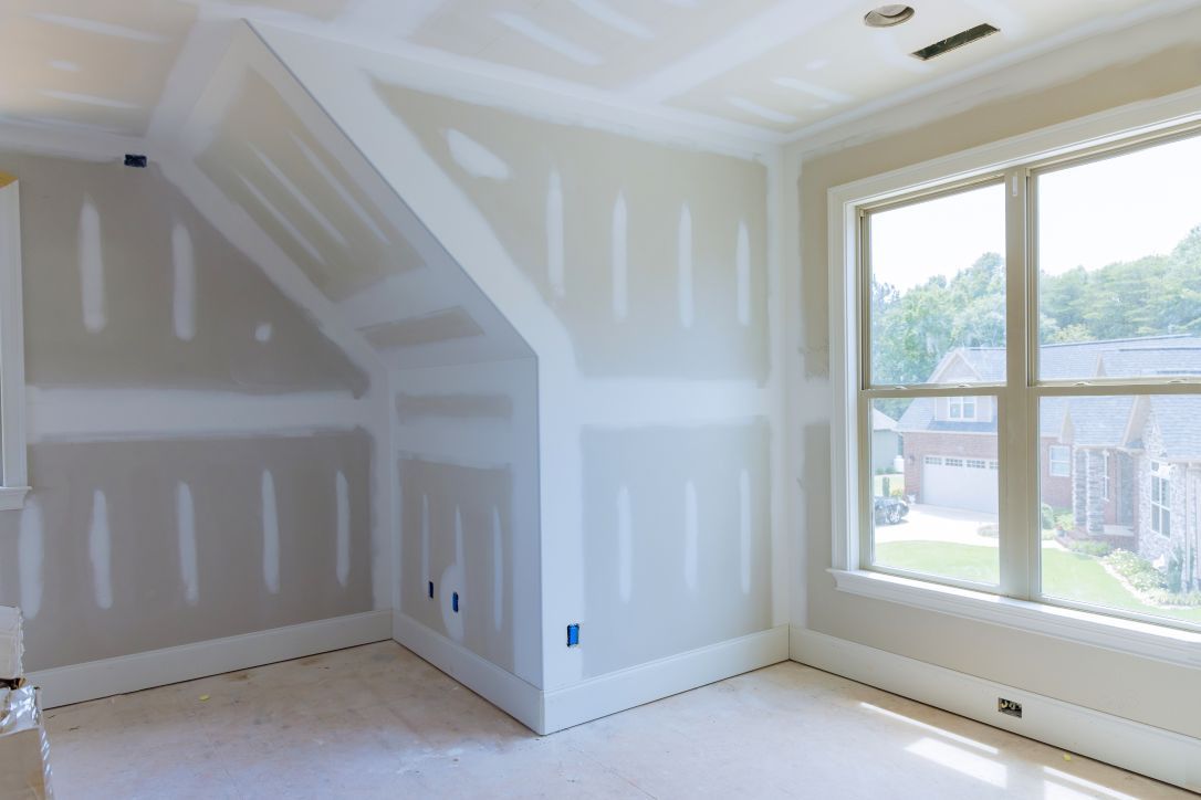 An empty room with a vaulted ceiling and a window.