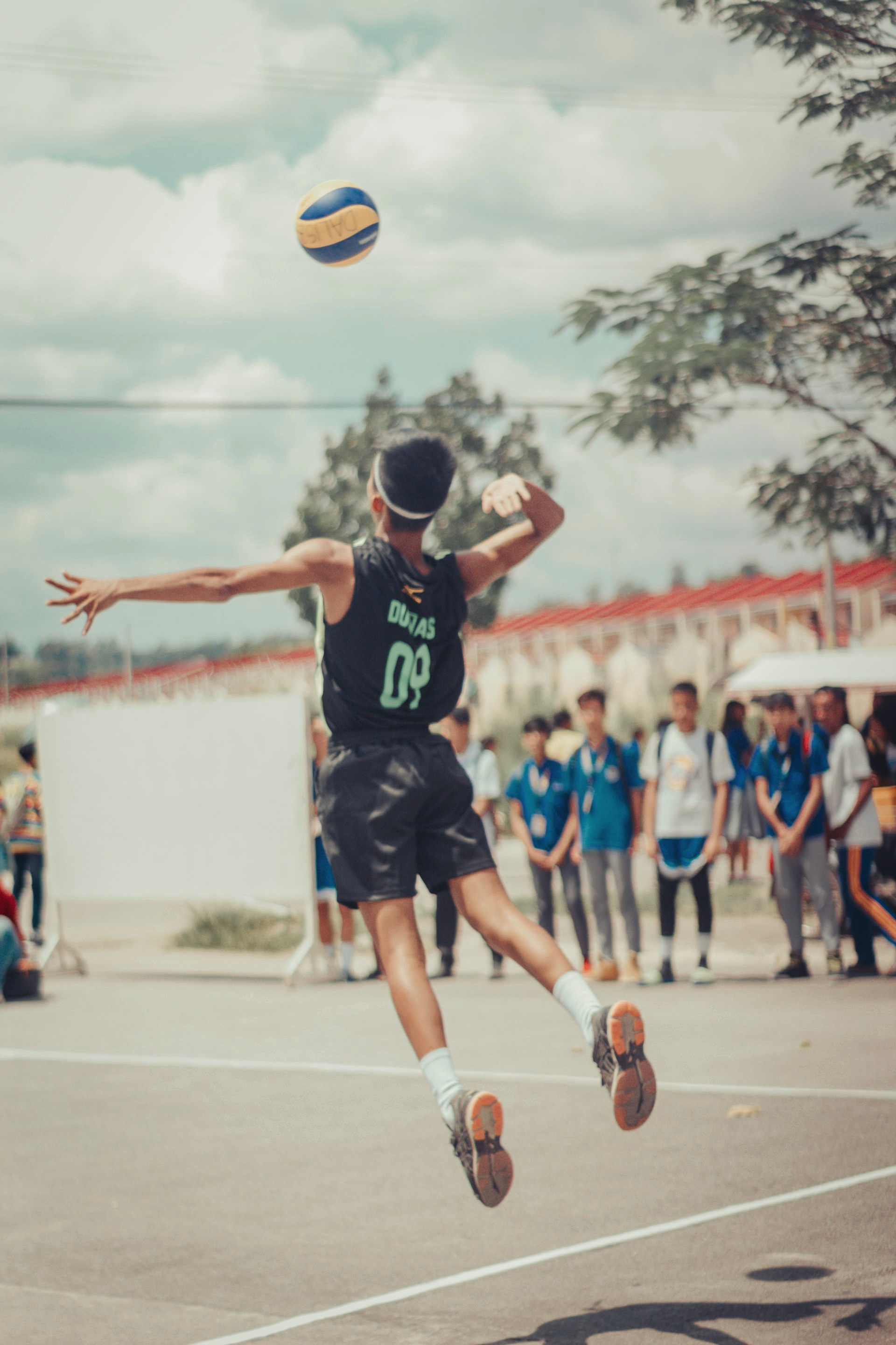een jongen die hoog springt voor volleybal