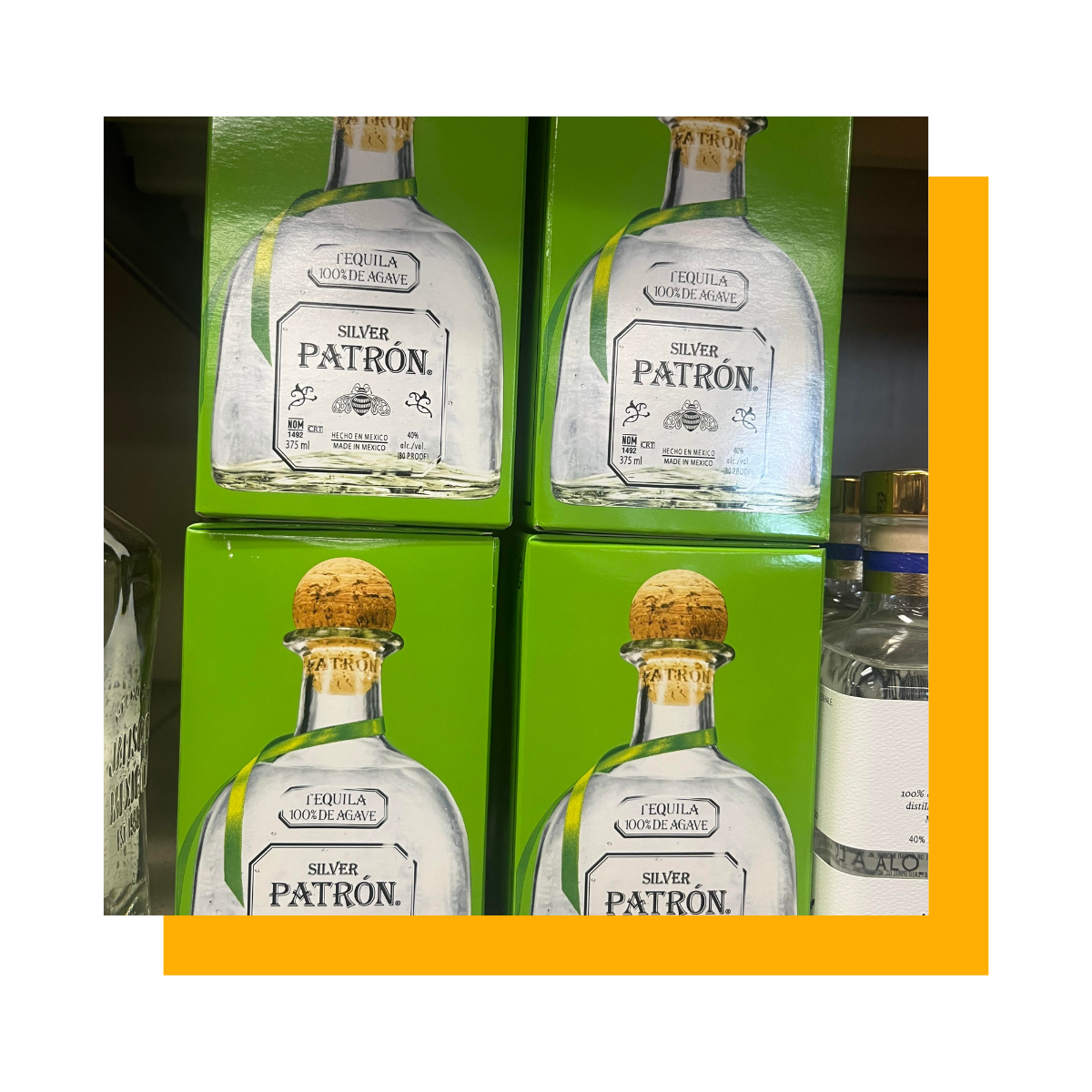 Four bottles of Patron tequila in green boxes on a shelf.