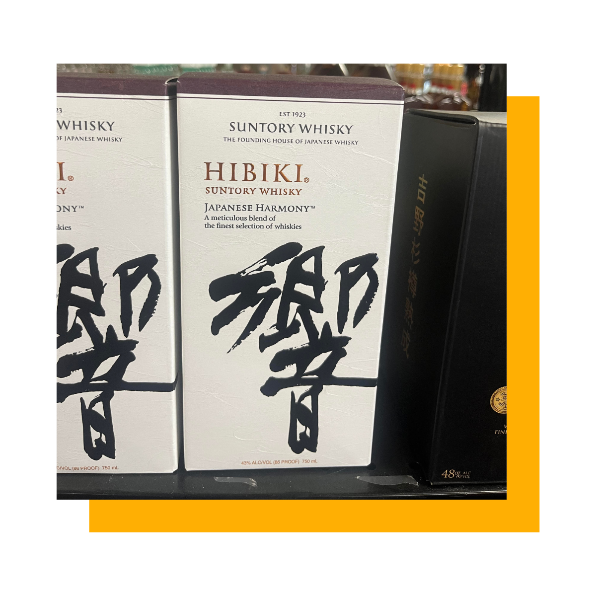 Boxes of Hibiki Suntory Japanese whisky on a store shelf, with white and black packaging.
