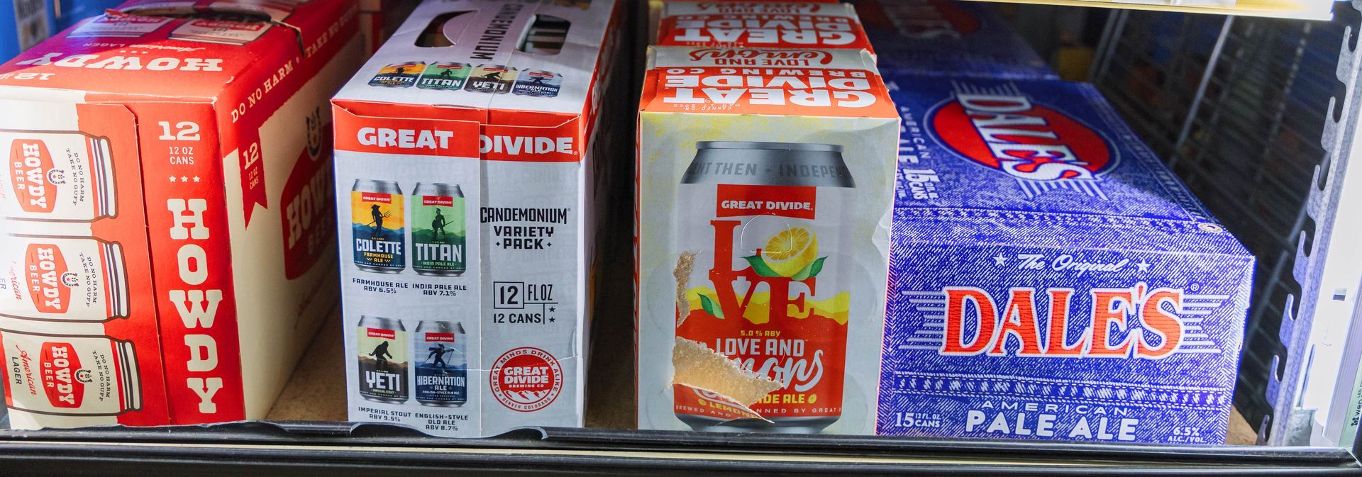 Assorted soda boxes on a shelf, including 