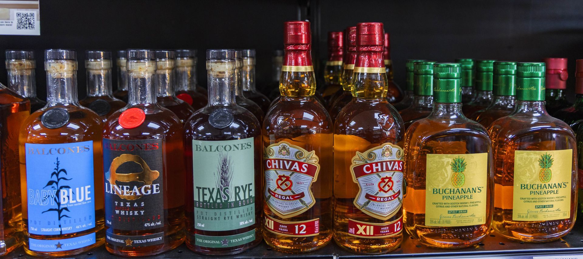 Bottles of liquor on a shelf with labels like 