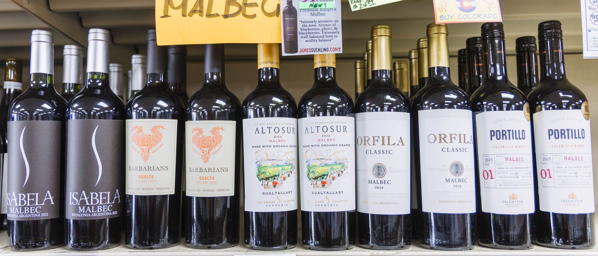 Row of various red wine bottles labeled 
