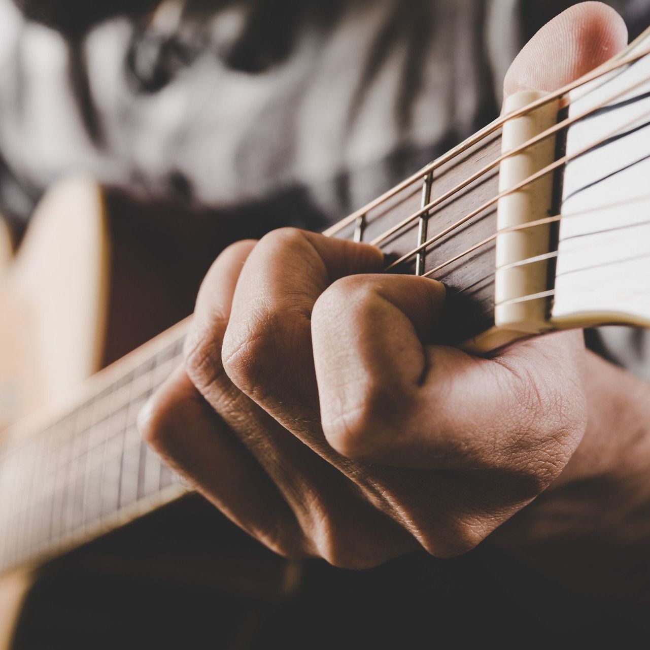 A close up of a person playing an acoustic guitar