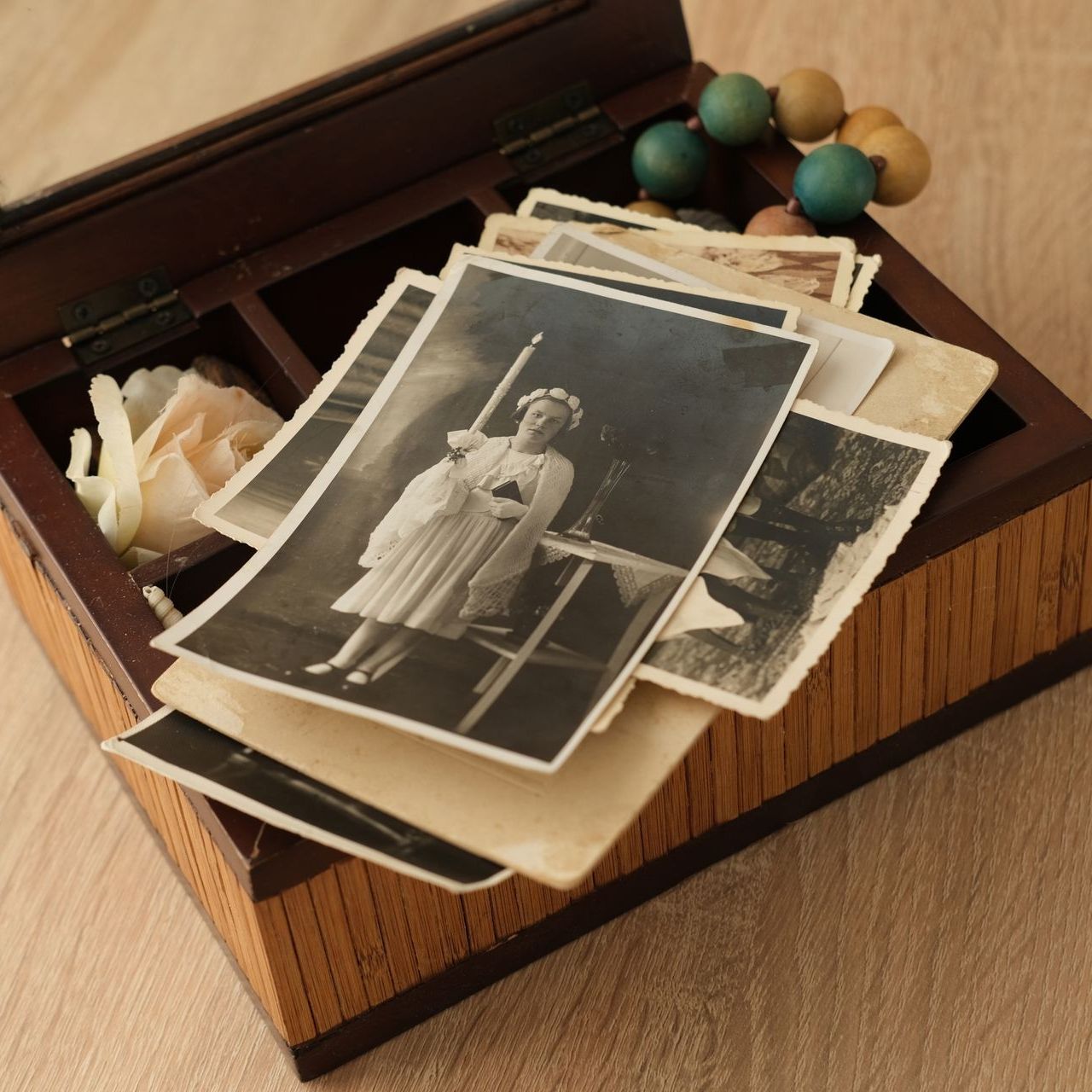 A stack of old photographs in a wooden box