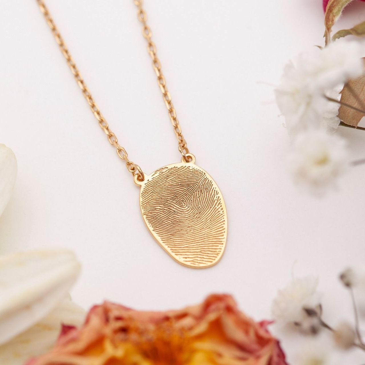 A gold necklace with a fingerprint on it