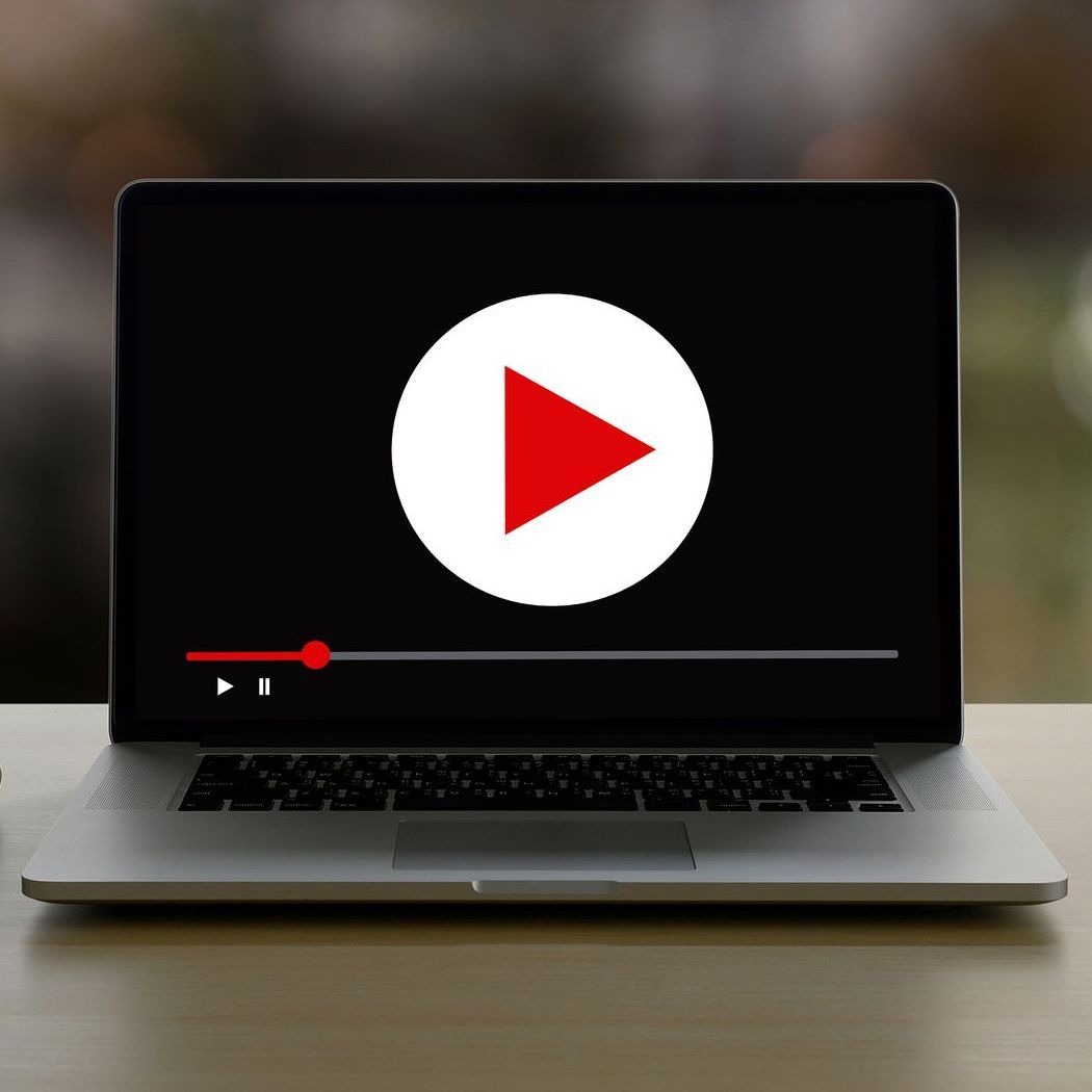 A laptop with a play button on the screen
