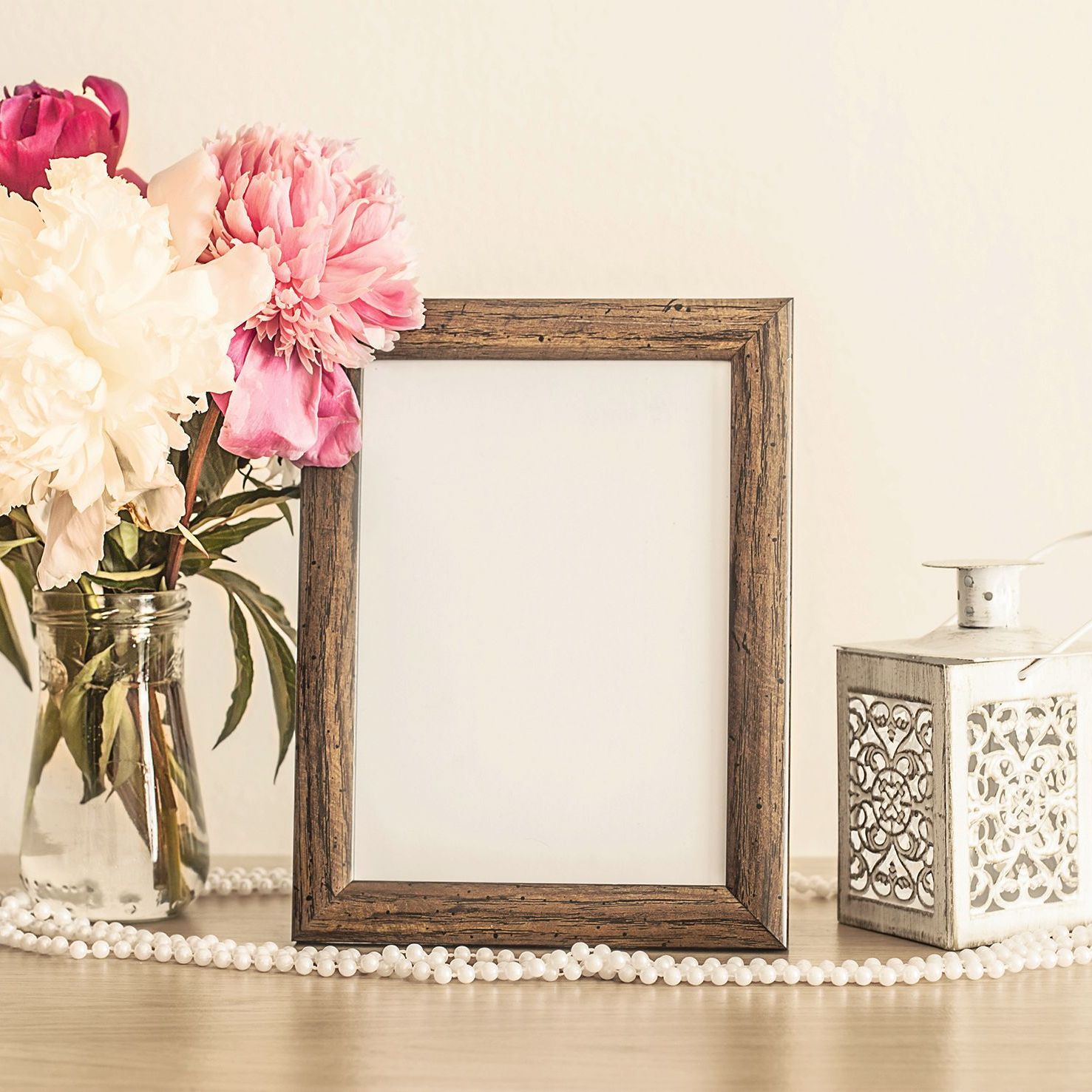 A picture frame is sitting on a table next to a vase of flowers.