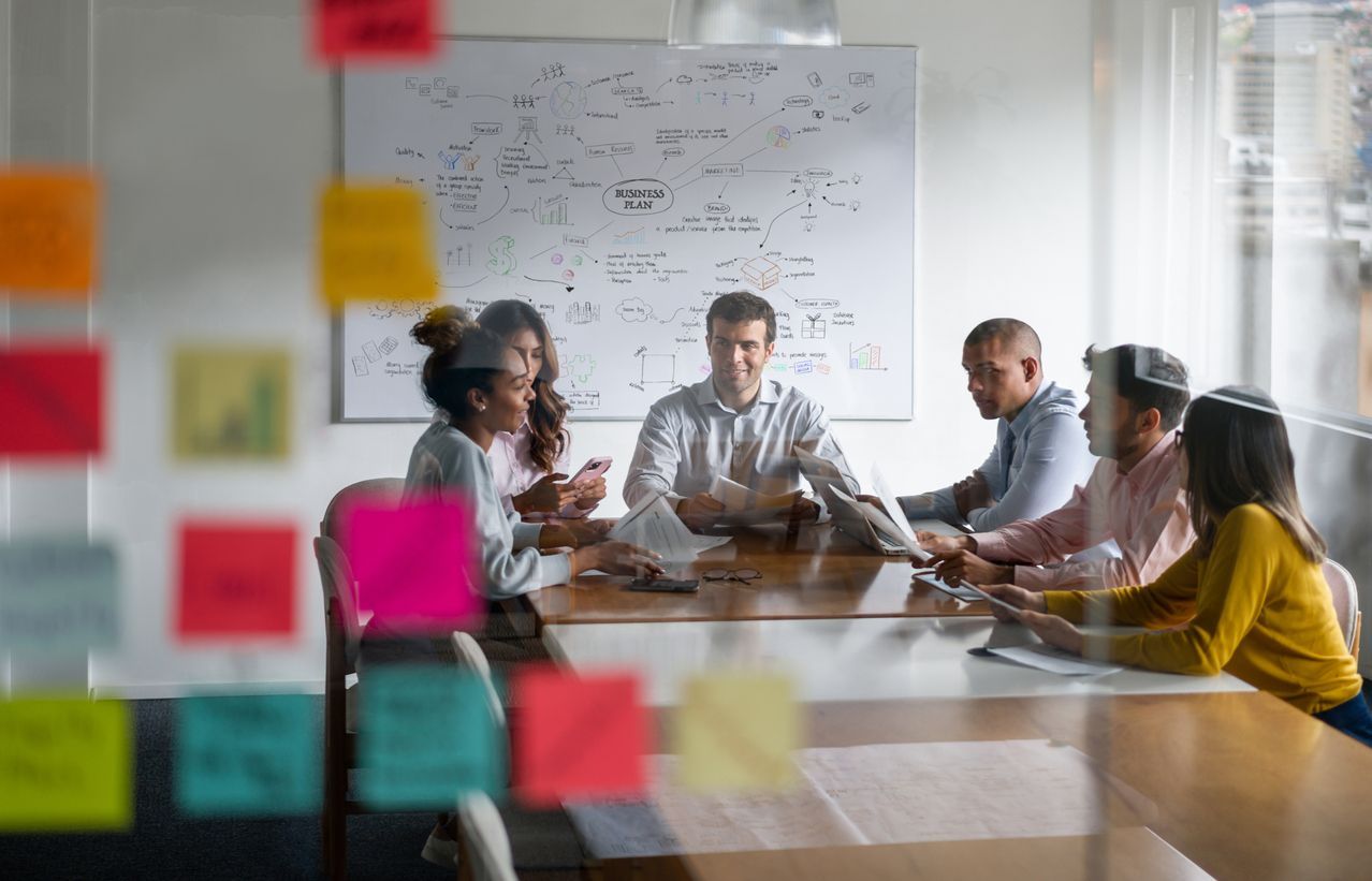 A group of people are sitting around a table in a conference room.