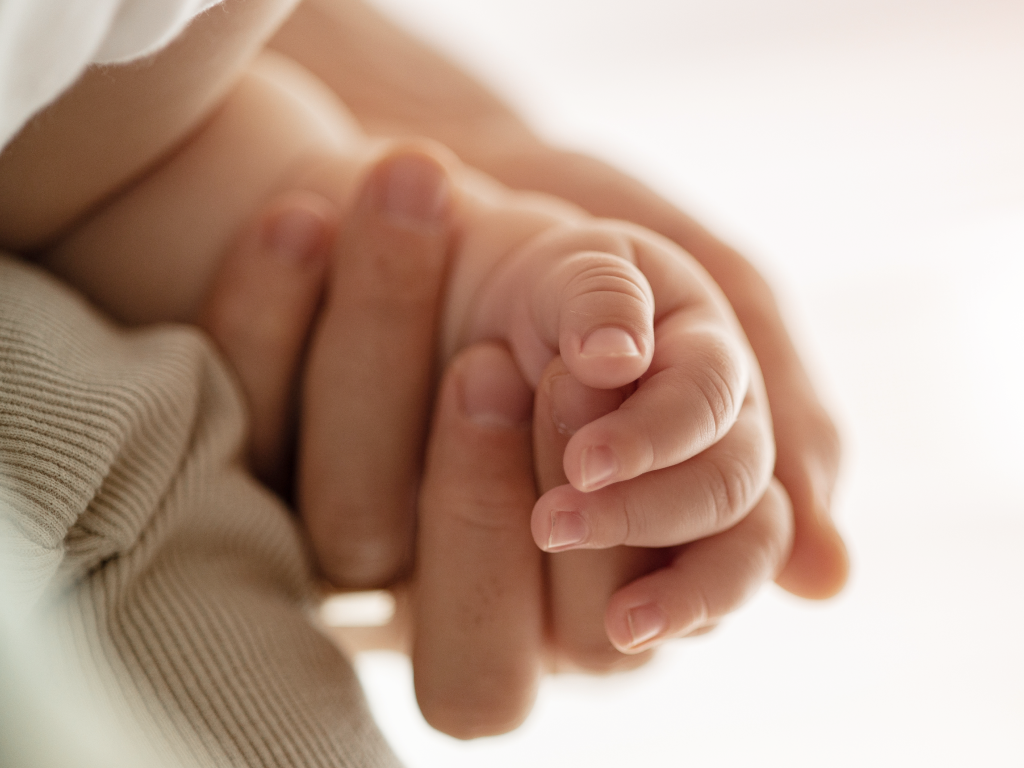 Mão de bebê segurando mão da mãe