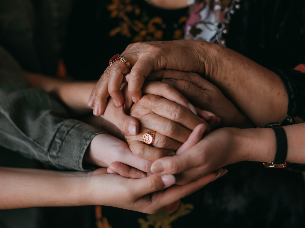 Um grupo de pessoas está de mãos dadas em um círculo.