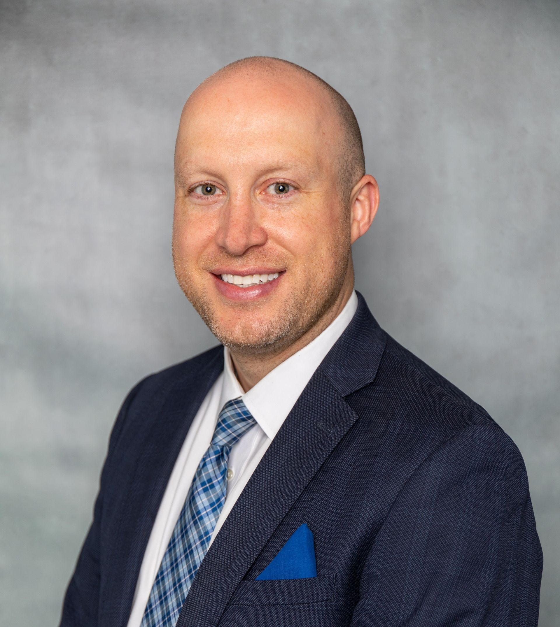 A man in a suit and tie is smiling for the camera.