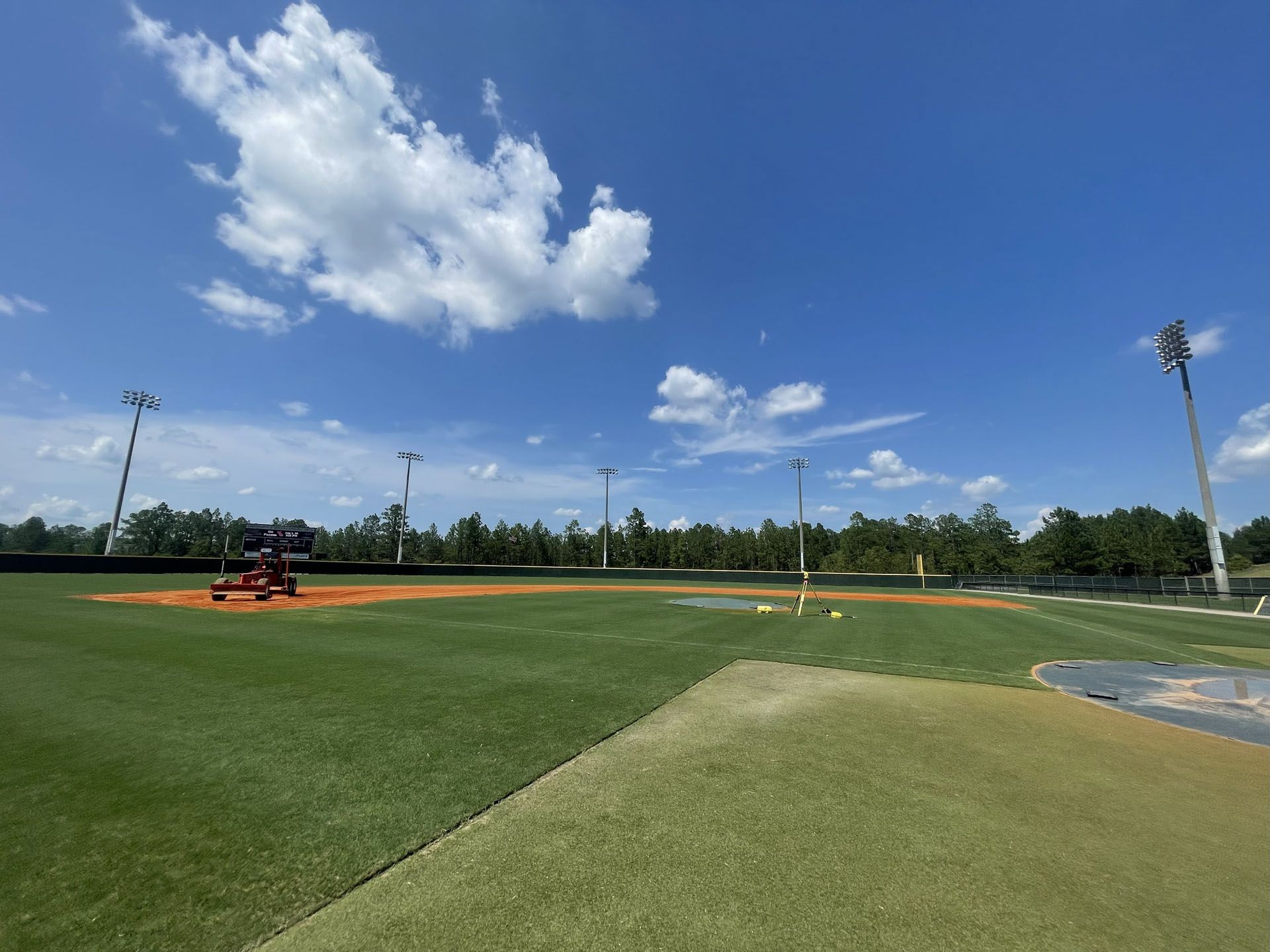 Baseball field under a blue sky, with some clouds.