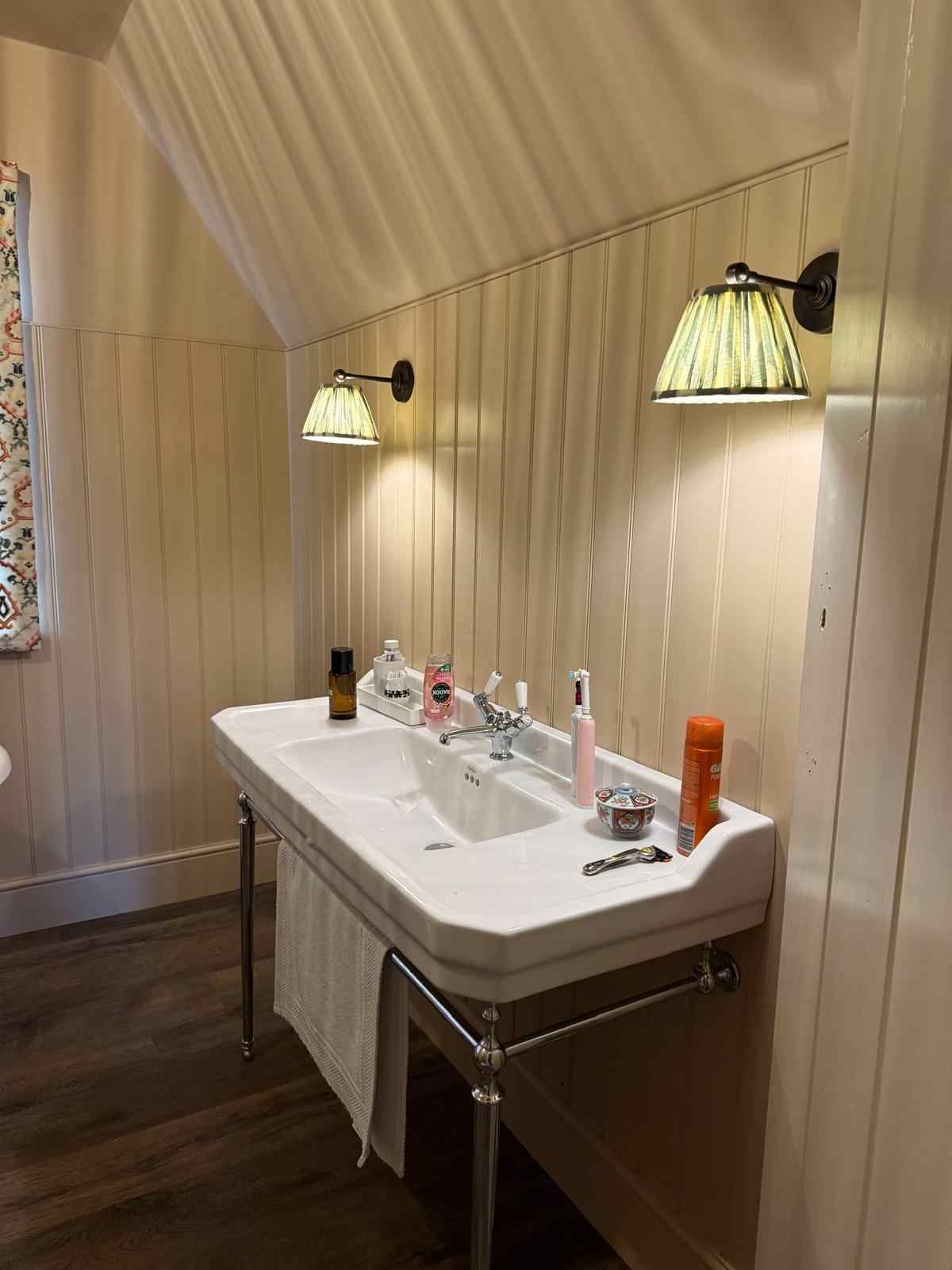 Renovated heritage property with electric sconce lights installed on a bathroom wall.
