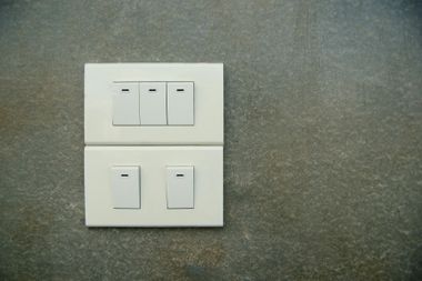 White light switches on gray wall.