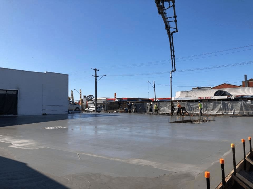 A Concrete Pump is Being Used to Pour Concrete Into a Parking Lot — Mackie's Concrete Pumping In Forster, NSW