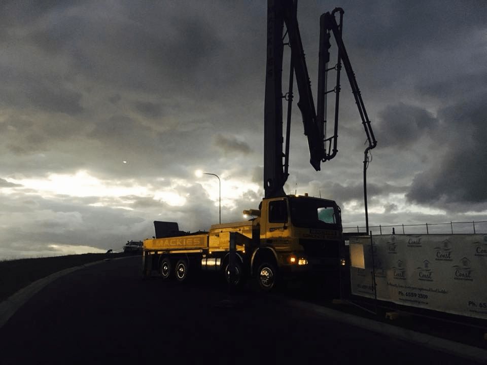 A Yellow Truck With a Concrete Pump Attached to It — Mackie's Concrete Pumping In Hallidays Point, NSW
