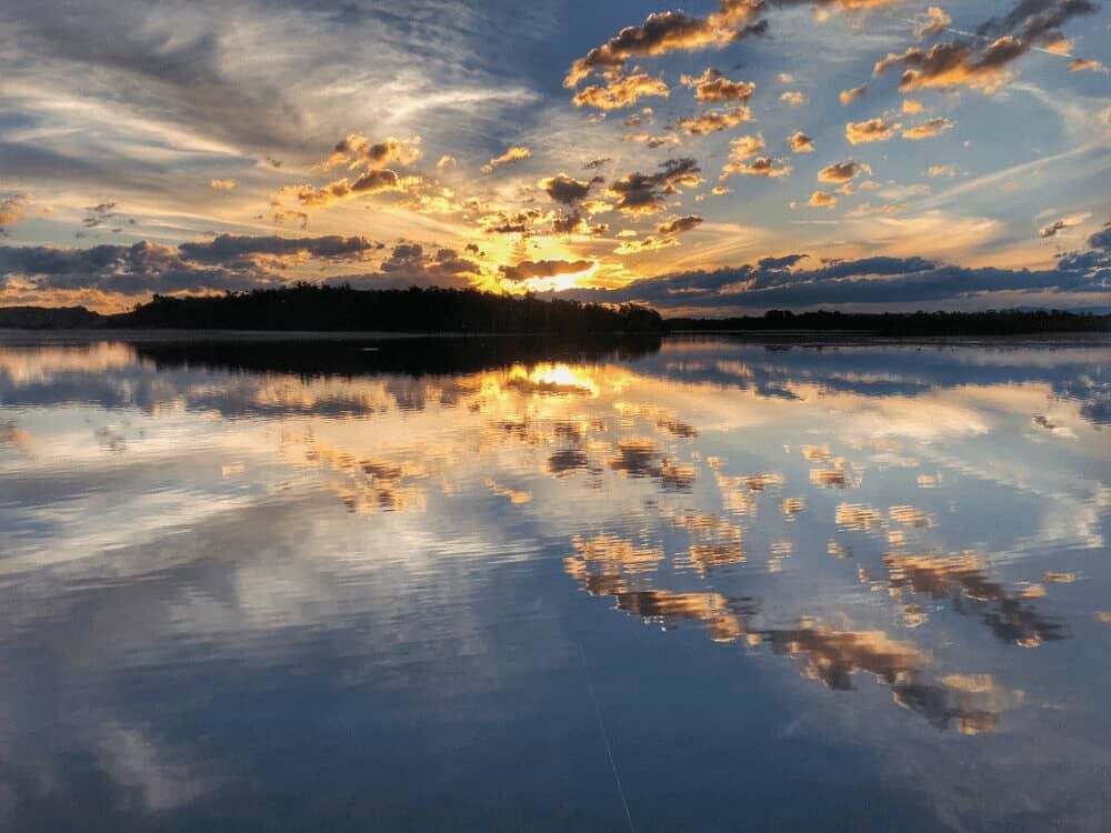 A Sunset Over a Lake With Clouds Reflected in the Water — Mackie's Concrete Pumping In Old Bar, NSW