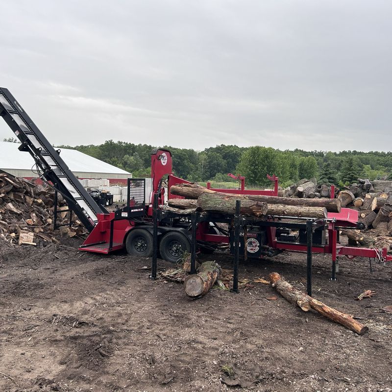 Firewood processing equipment splitting logs at a job site in Bristol, WI