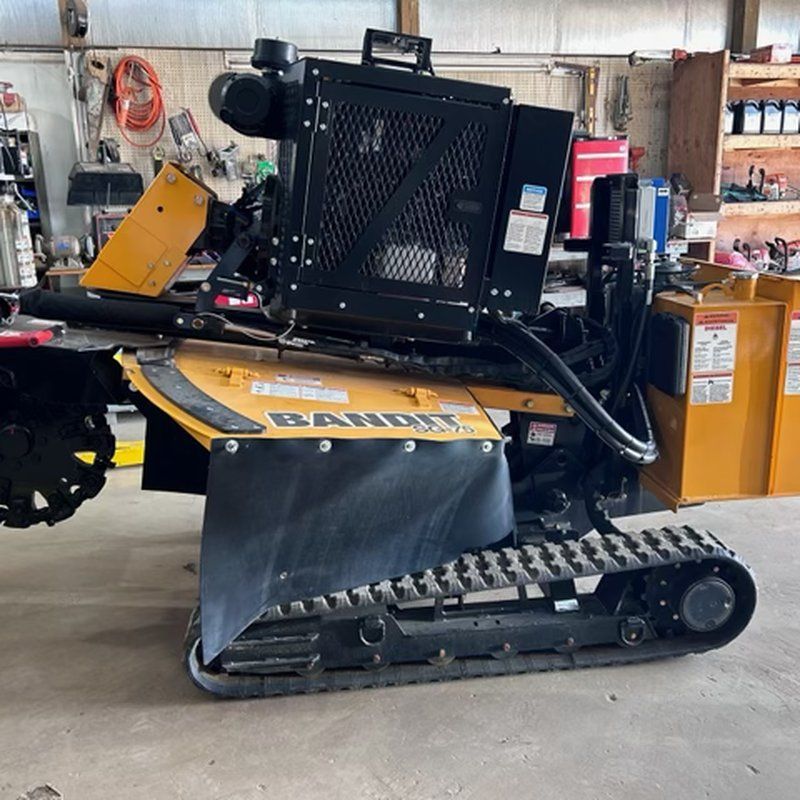 Compact tracked stump grinder stored in equipment garage, Kenosha, WI