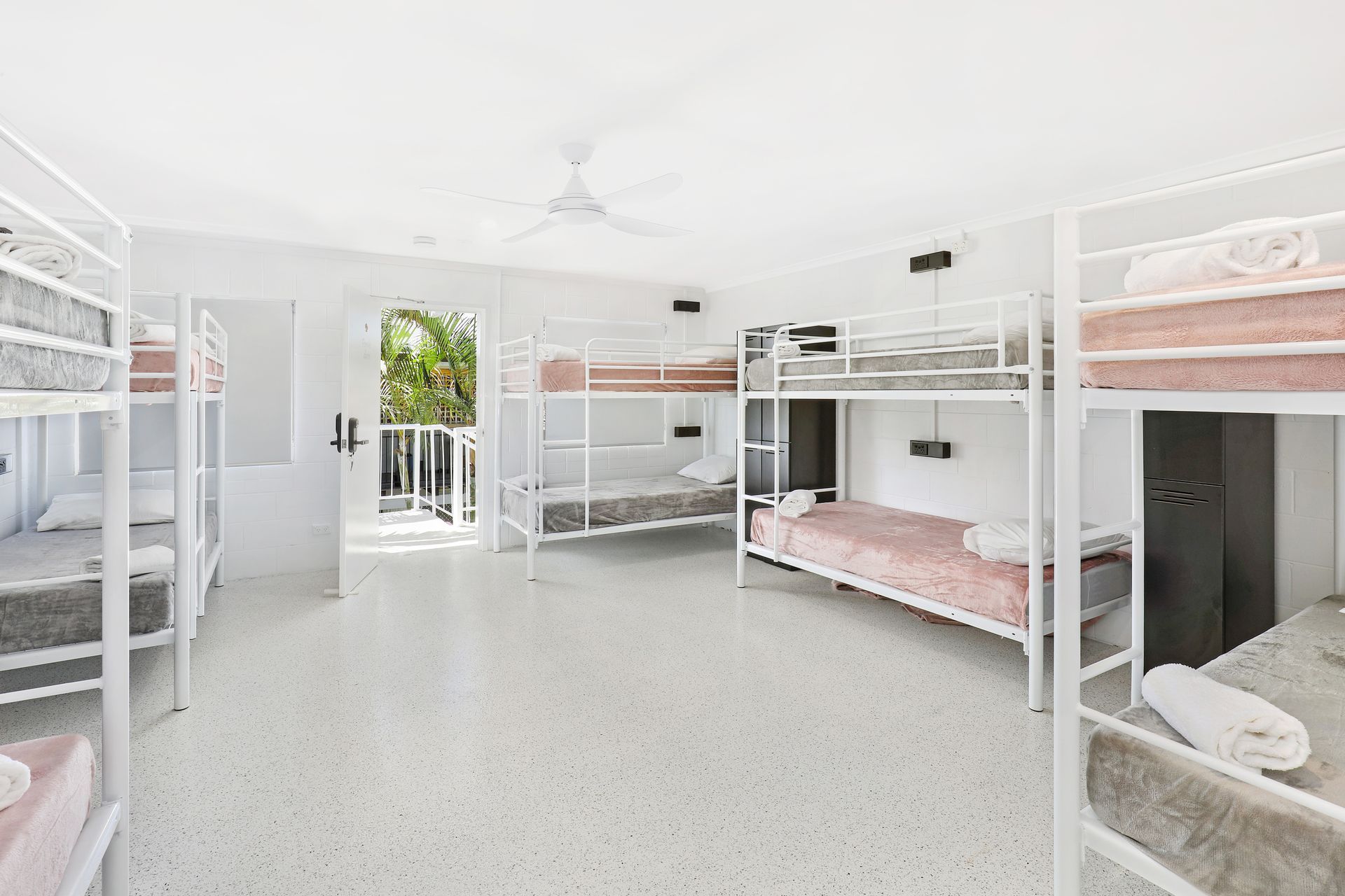 A room filled with bunk beds and a ceiling fan.