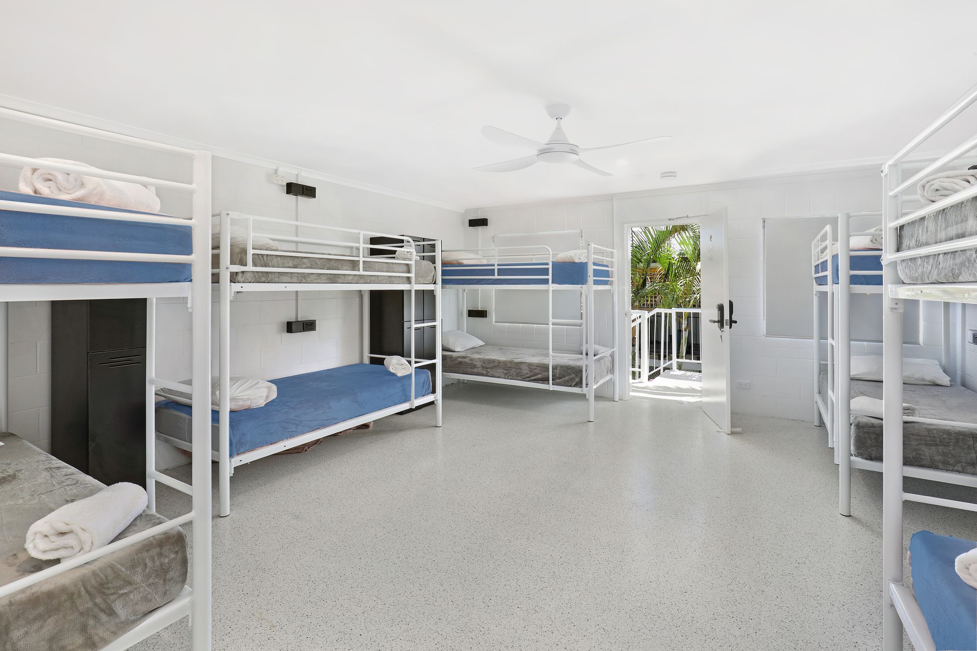 A room filled with bunk beds and a ceiling fan.
